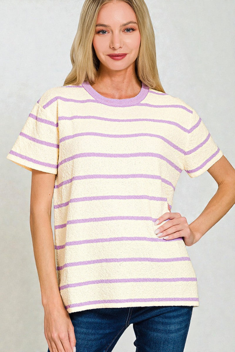 Woman wearing a yellow and purple striped shirt against a plain background