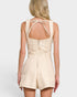 Beige romper with bow detail on a plain background