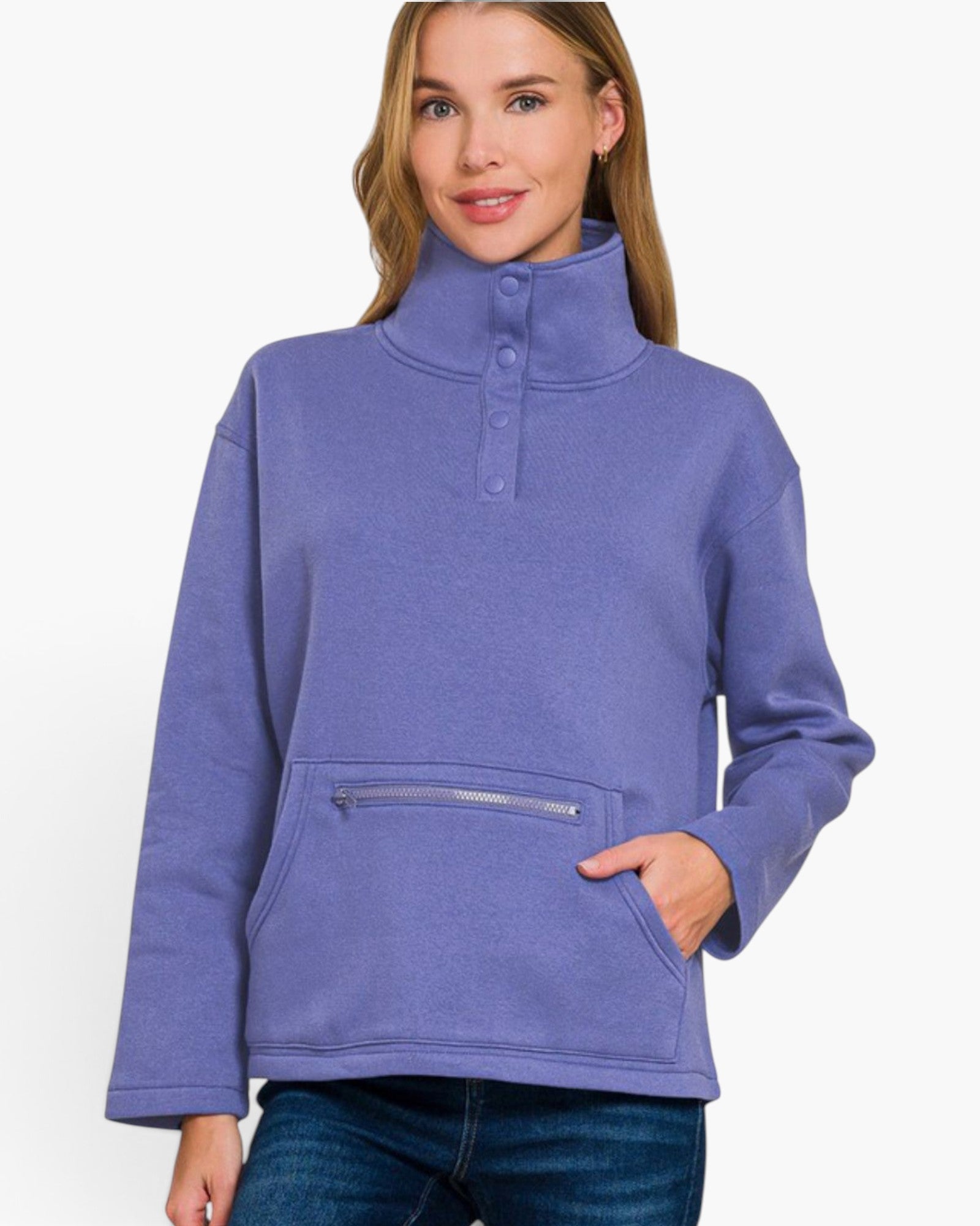 A woman wearing a lavender-purple long-sleeve mock-neck fleece pullover with a buttoned collar and a zippered front kangaroo pocket, paired with blue jeans against a plain white background.