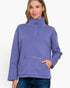 A woman wearing a lavender-purple long-sleeve mock-neck fleece pullover with a buttoned collar and a zippered front kangaroo pocket, paired with blue jeans against a plain white background.