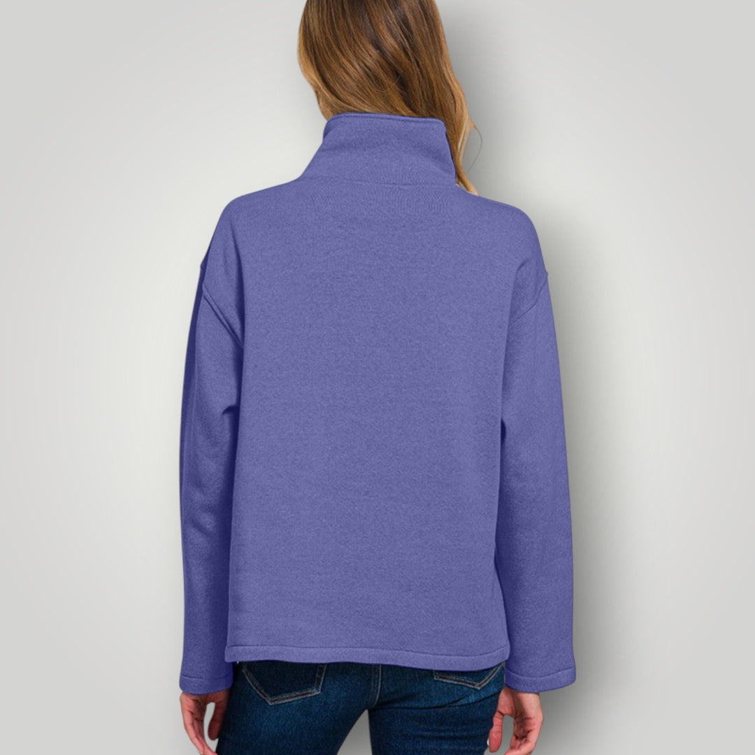 Person wearing a purple long-sleeve shirt against a plain background