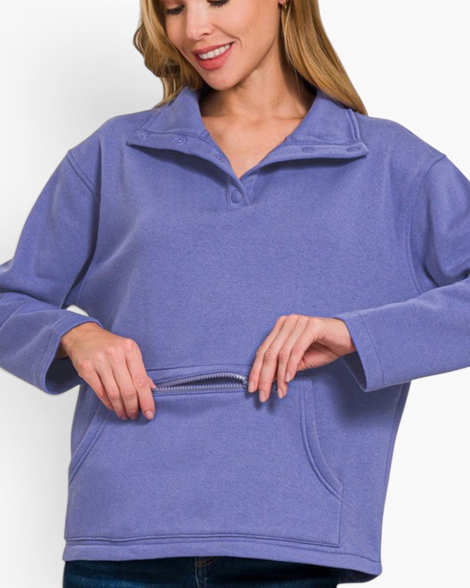 A woman wearing a heathered periwinkle blue quarter-zip pullover sweatshirt, shown from the chest down, demonstrating a front kangaroo pocket with a zippered opening.