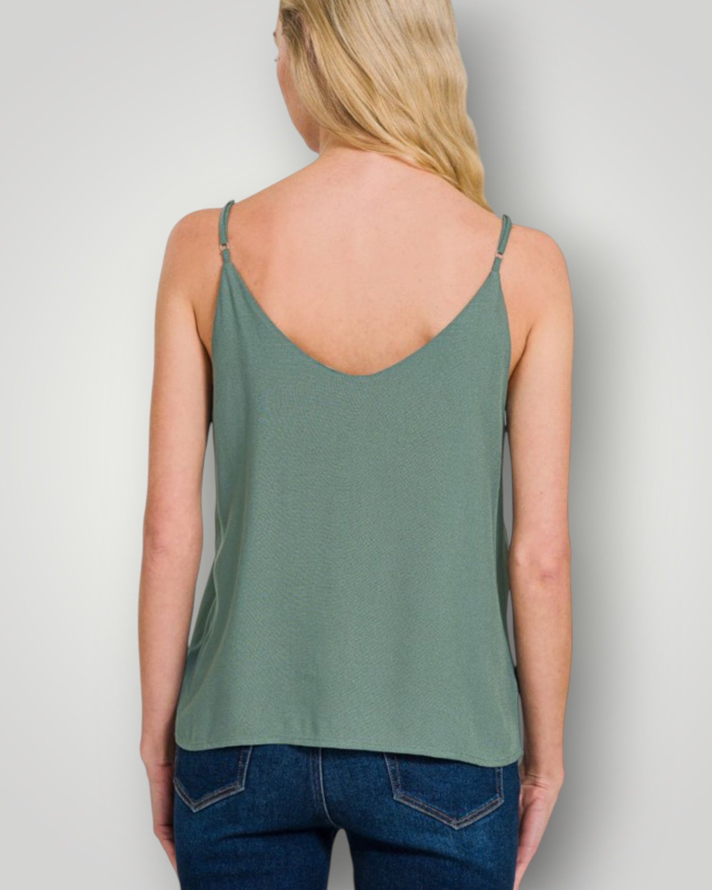 Woman wearing a green tank top against a plain background