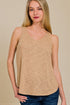 Woman wearing a beige tank top against a beige background