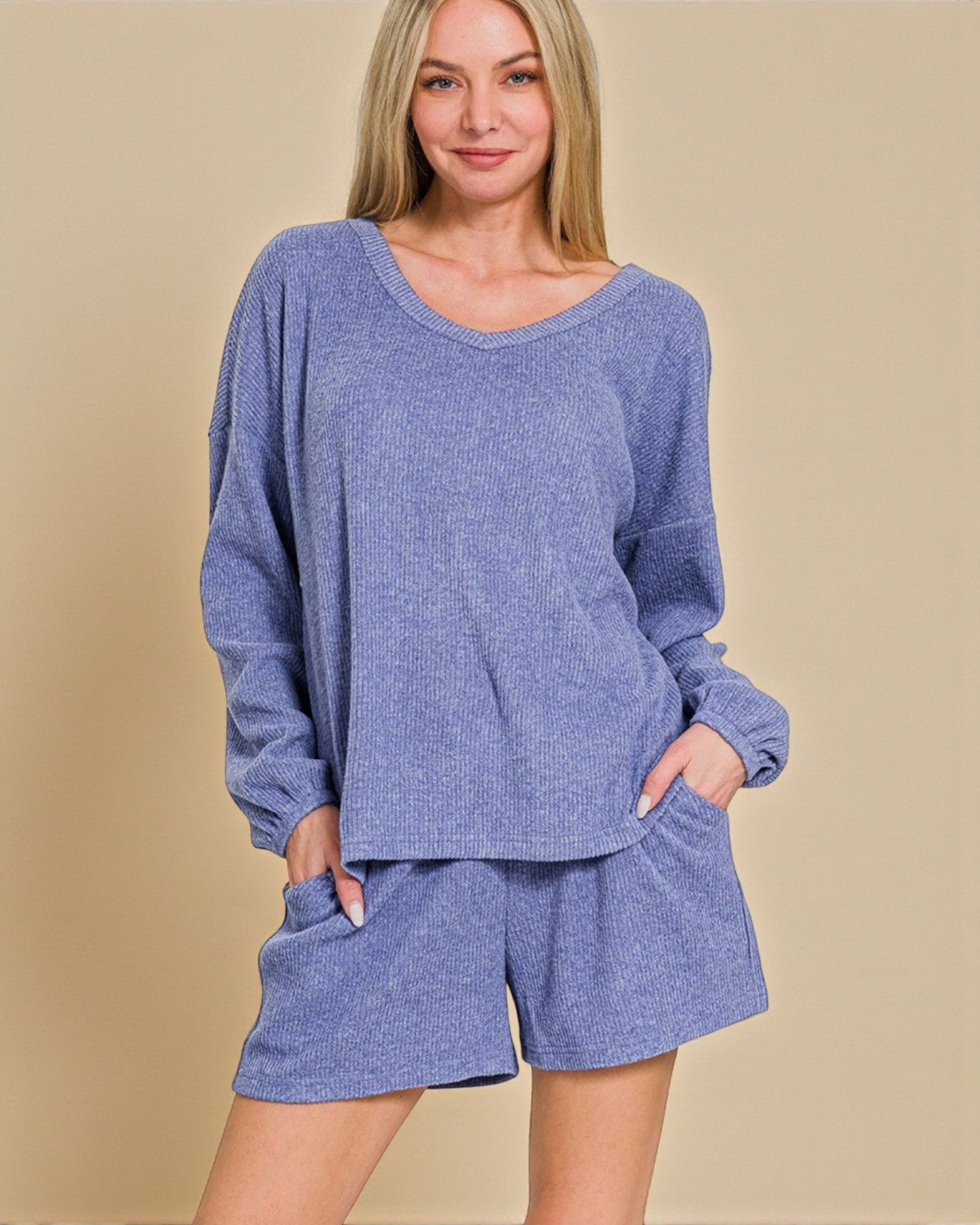 Woman wearing a blue lounge set on a beige background