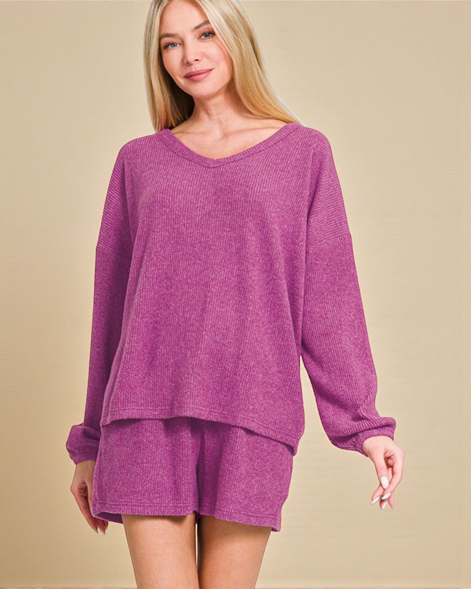 Woman wearing a purple loungewear set on a beige background
