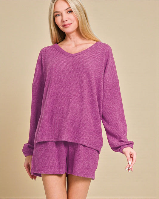 Woman wearing a purple loungewear set on a beige background