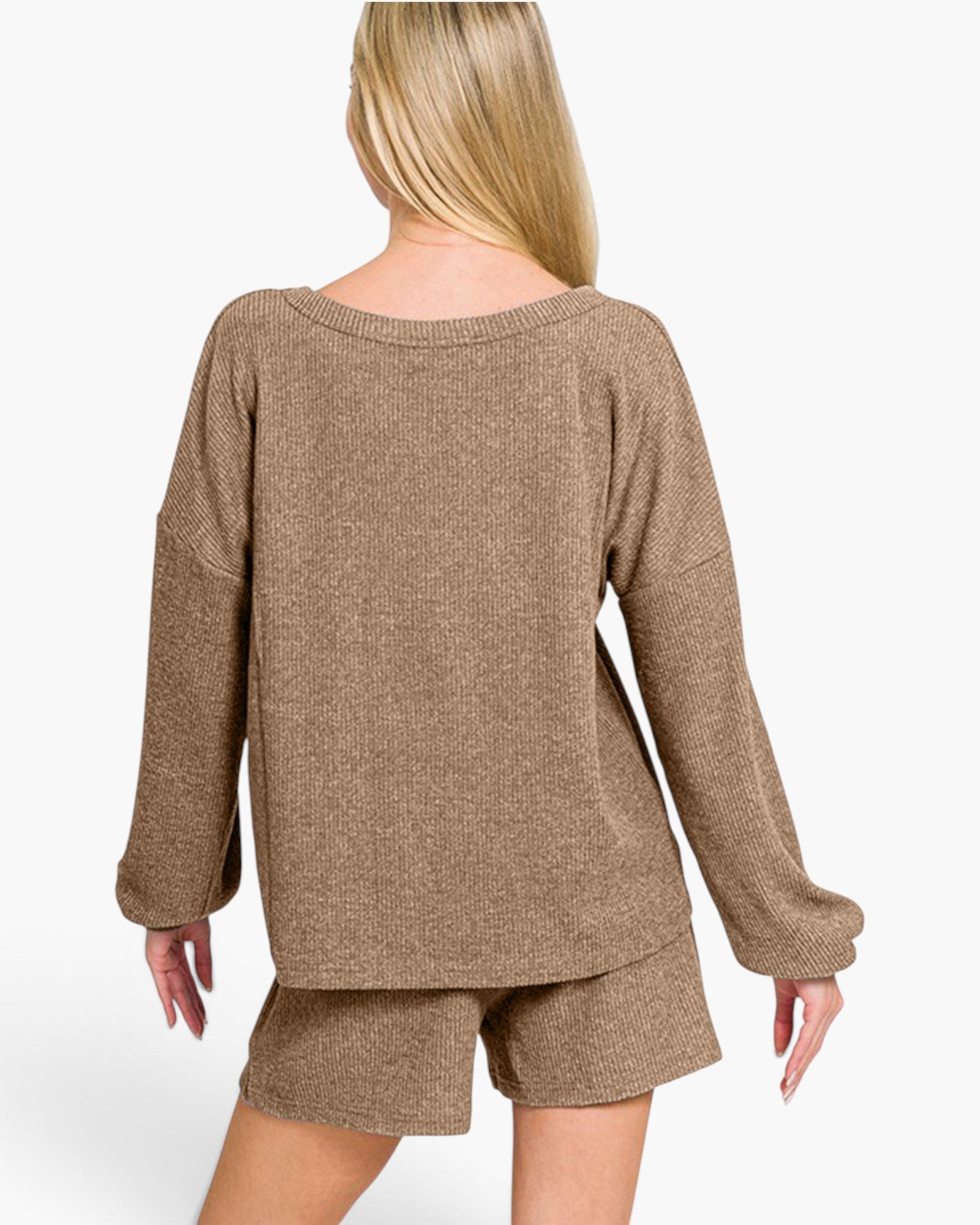 A woman shown from the back wearing a loose, heathered taupe-brown knit sweater and matching shorts against a plain light gray studio background.