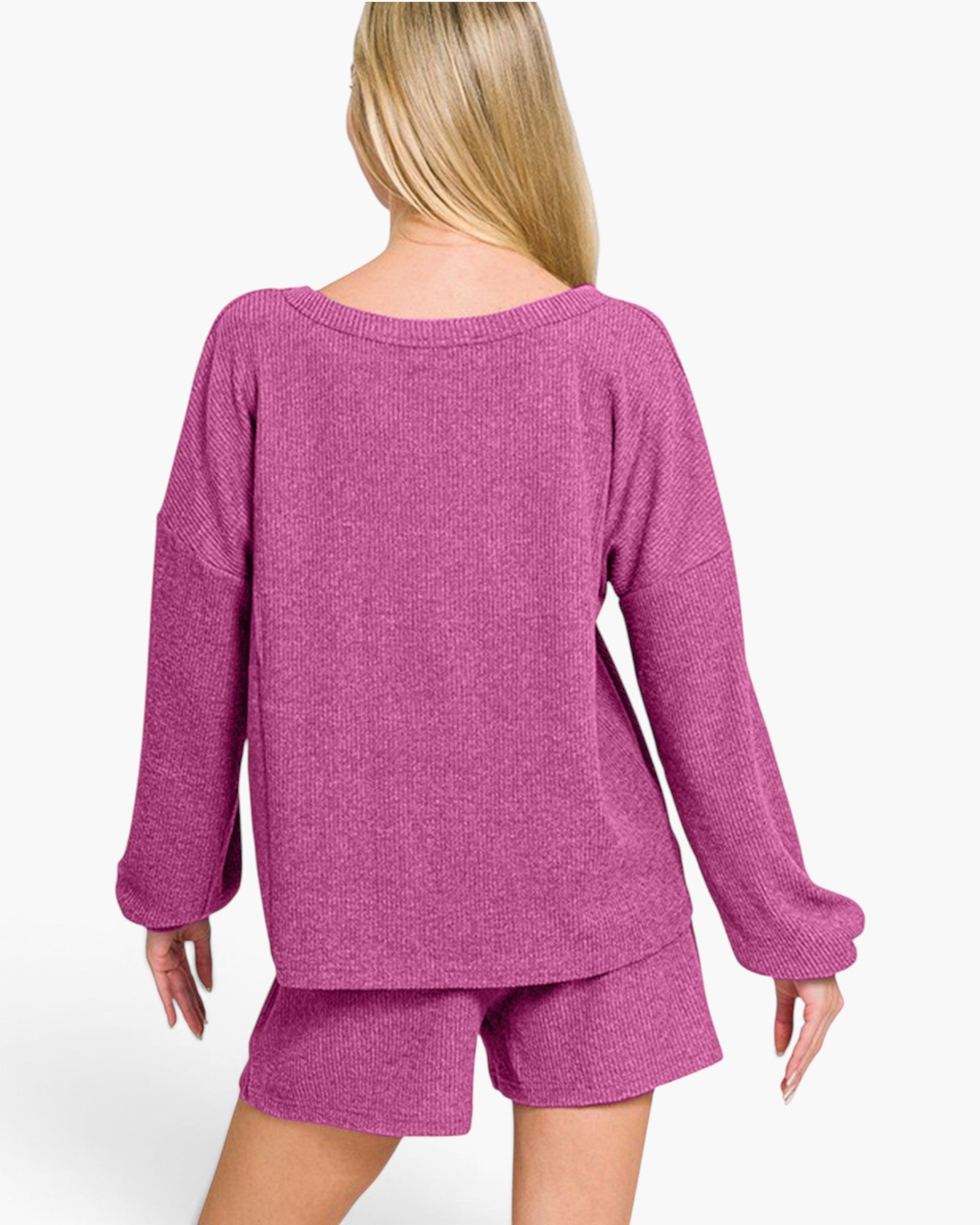 A woman shown from the back wearing a heathered magenta knit lounge set consisting of a long-sleeve top and matching shorts, against a plain white studio background.