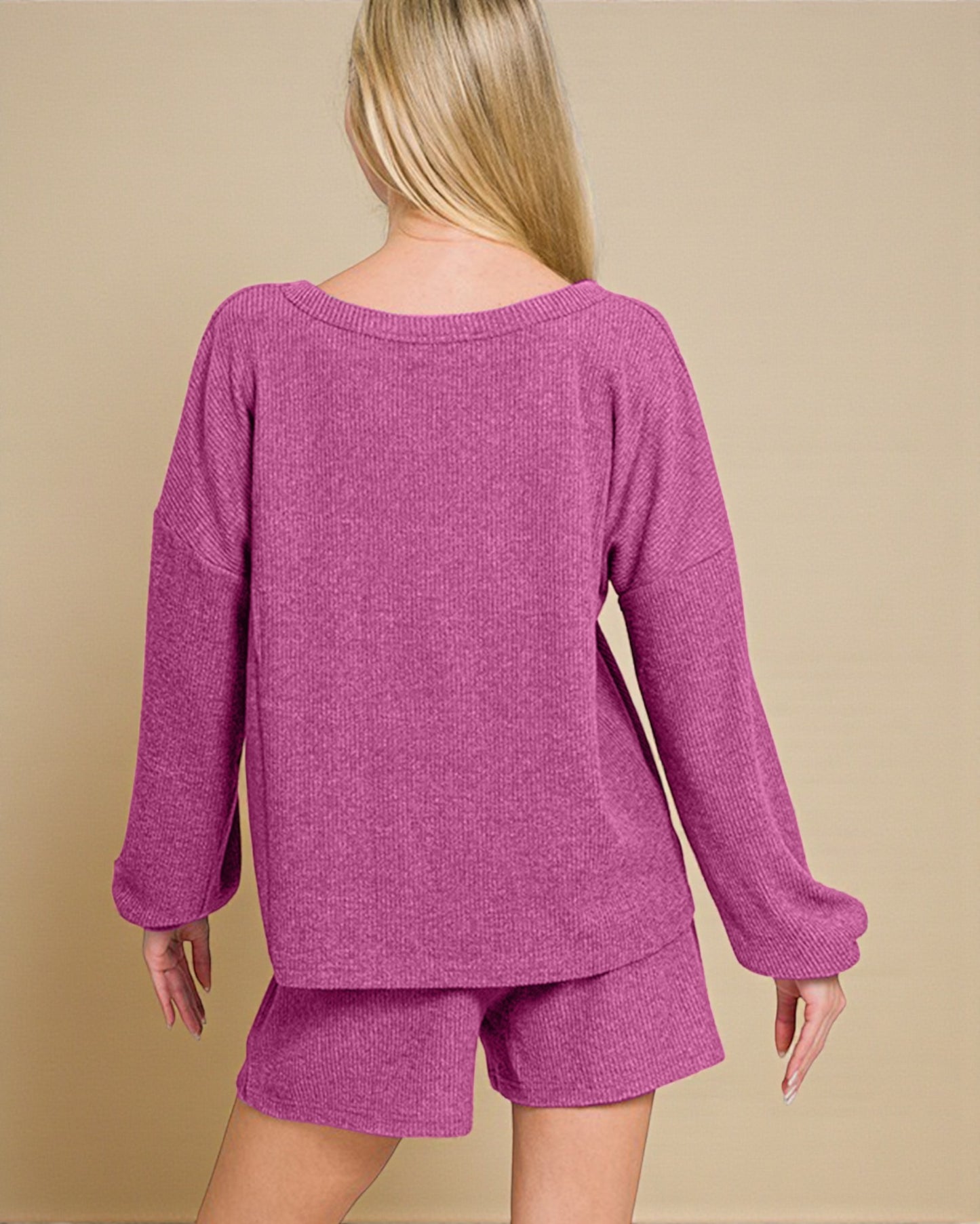 Person wearing a purple sweater and shorts set on a beige background