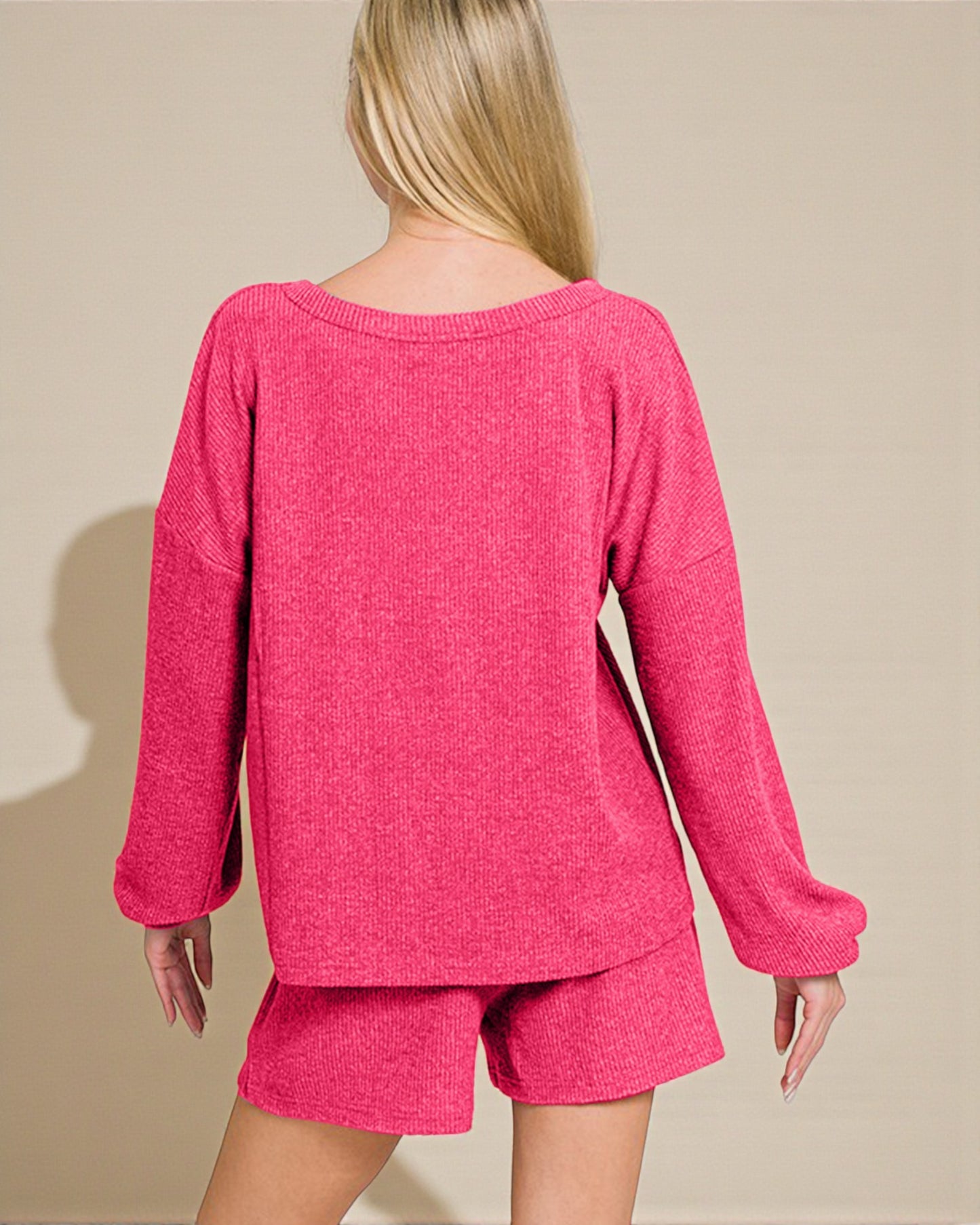 Person wearing a pink knitted outfit on a beige background