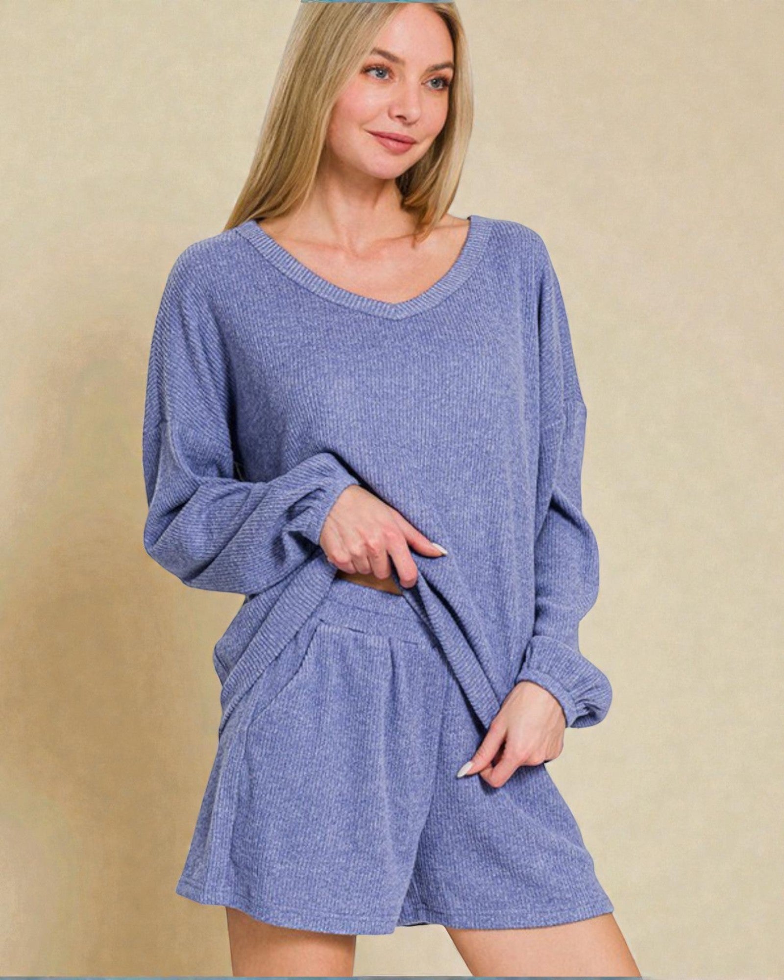 Woman wearing a blue knit outfit on a beige background