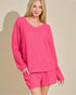 Woman wearing a pink outfit with a plain background