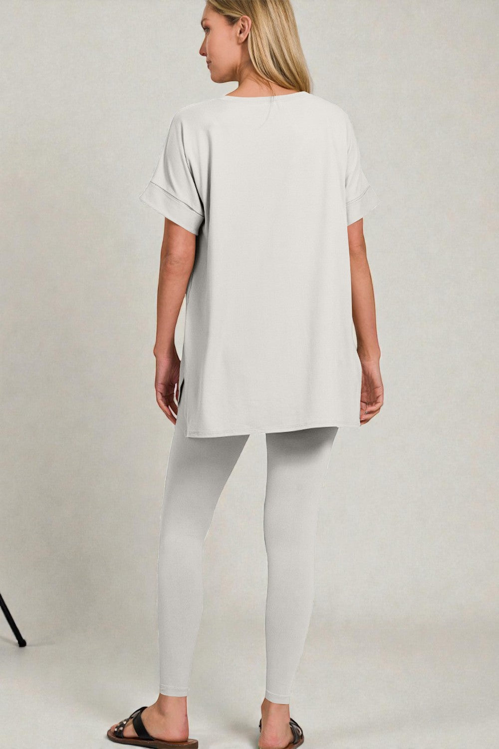 Woman wearing a white outfit on a plain background