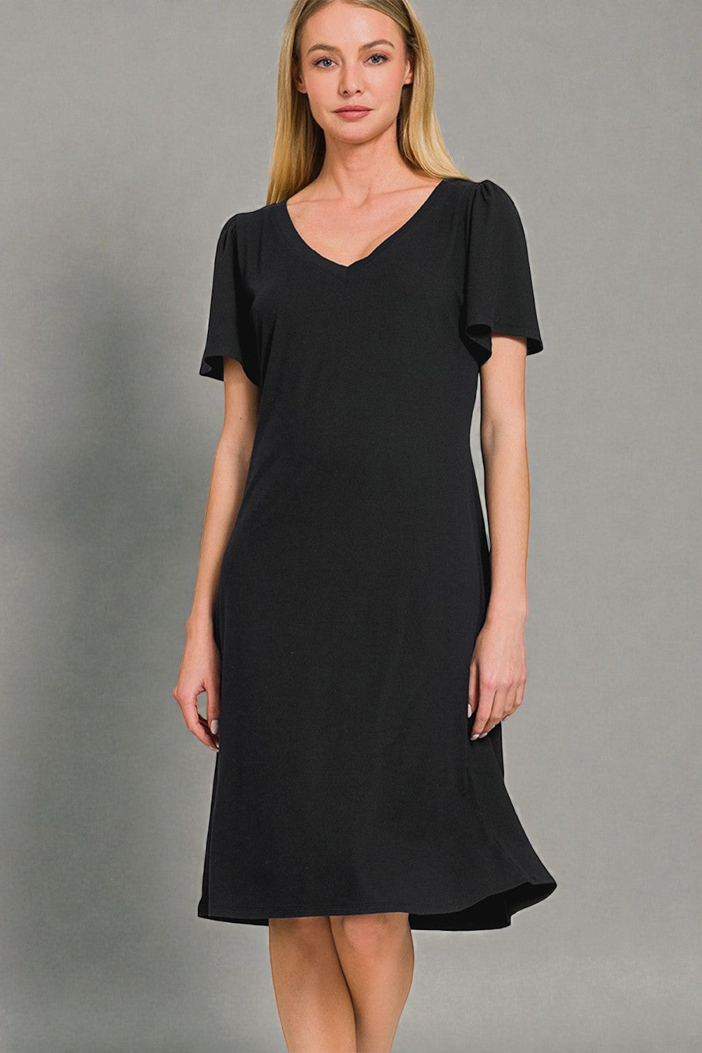 Woman wearing a black dress against a gray background