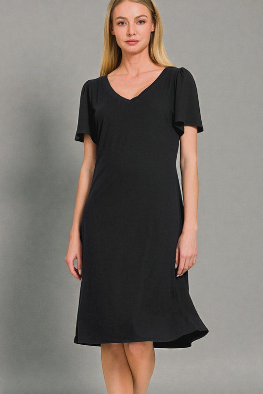 Woman wearing a black dress against a gray background