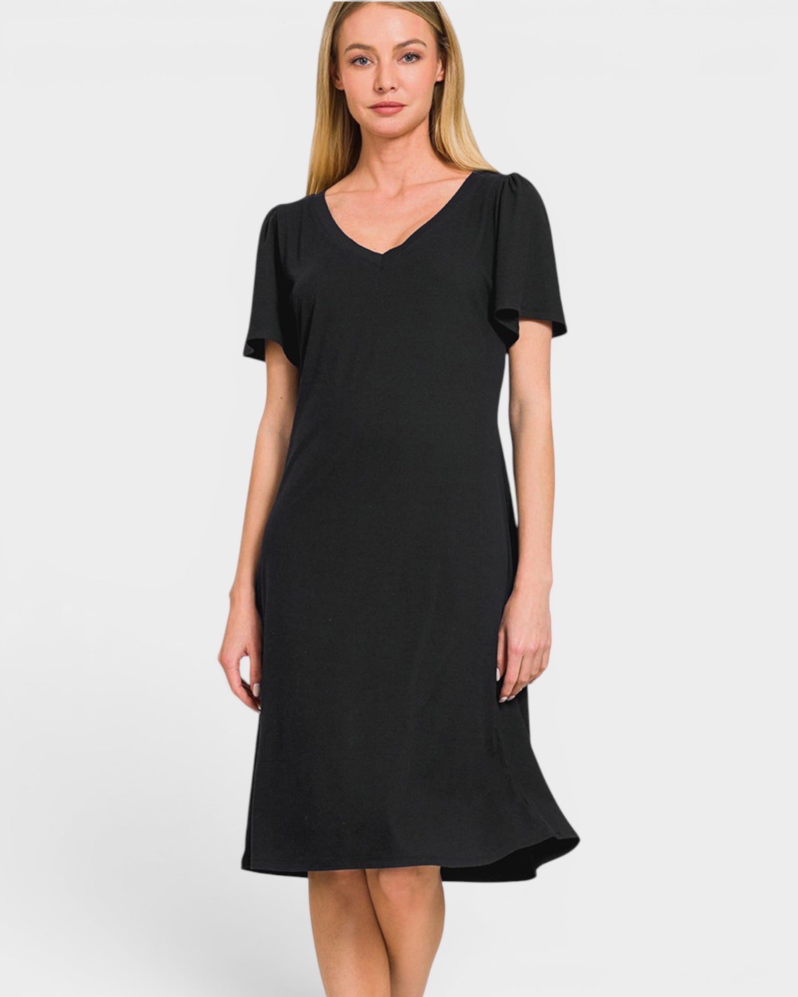 A woman modeling a black short-sleeve V-neck dress with a flared hem against a light gray studio background.