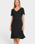 A woman modeling a black short-sleeve V-neck dress with a flared hem against a light gray studio background.