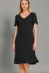 Woman wearing a black dress against a gray background