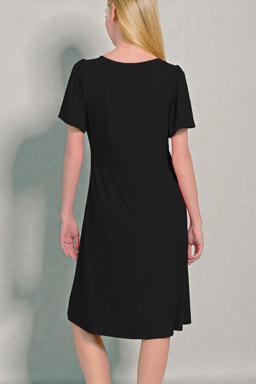 Black dress worn by a person on a plain background