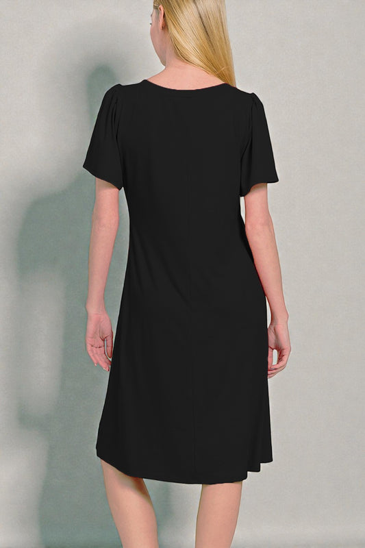 Black dress worn by a person on a plain background