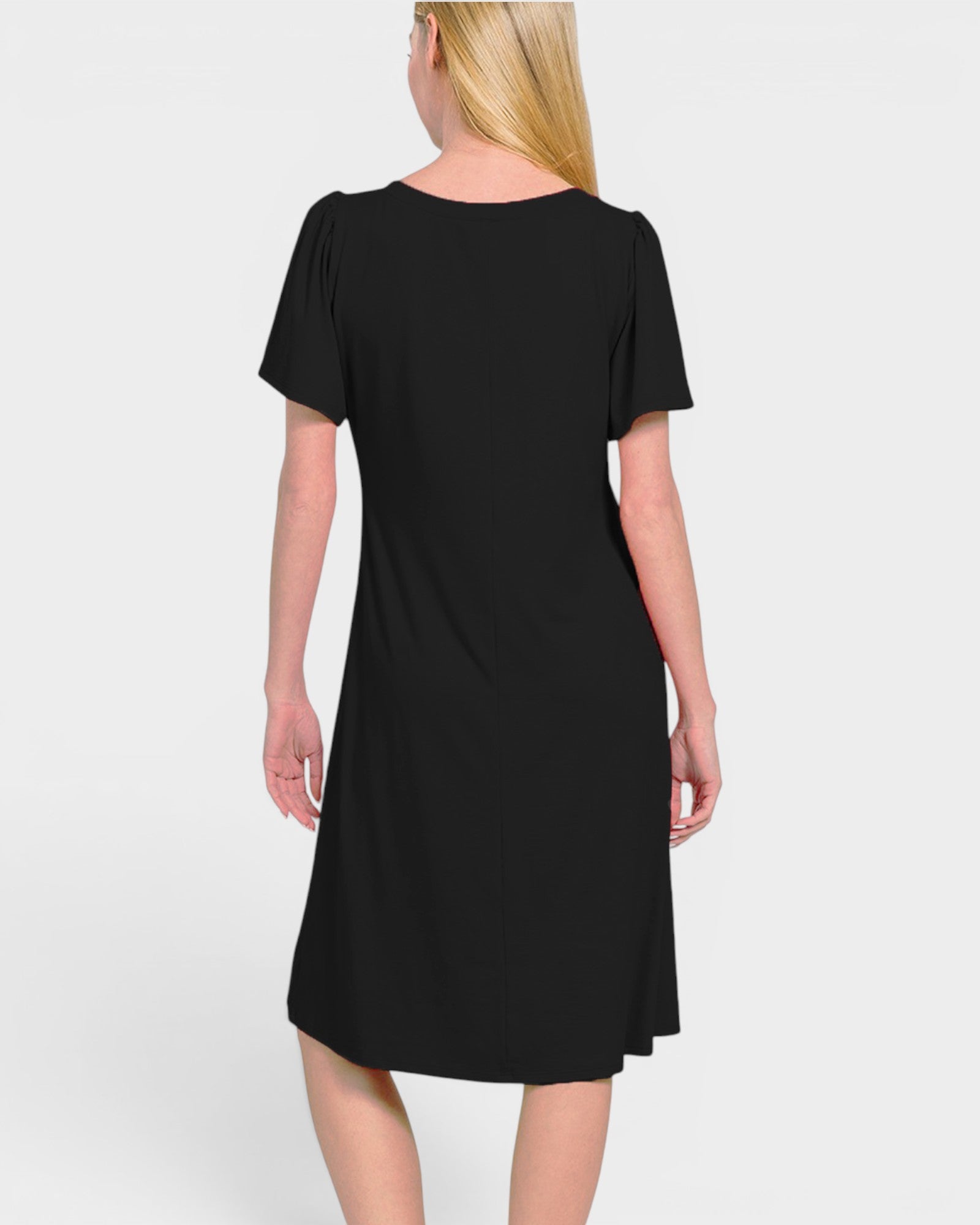 A woman shown from the back wearing a short-sleeve black dress against a light gray studio background.