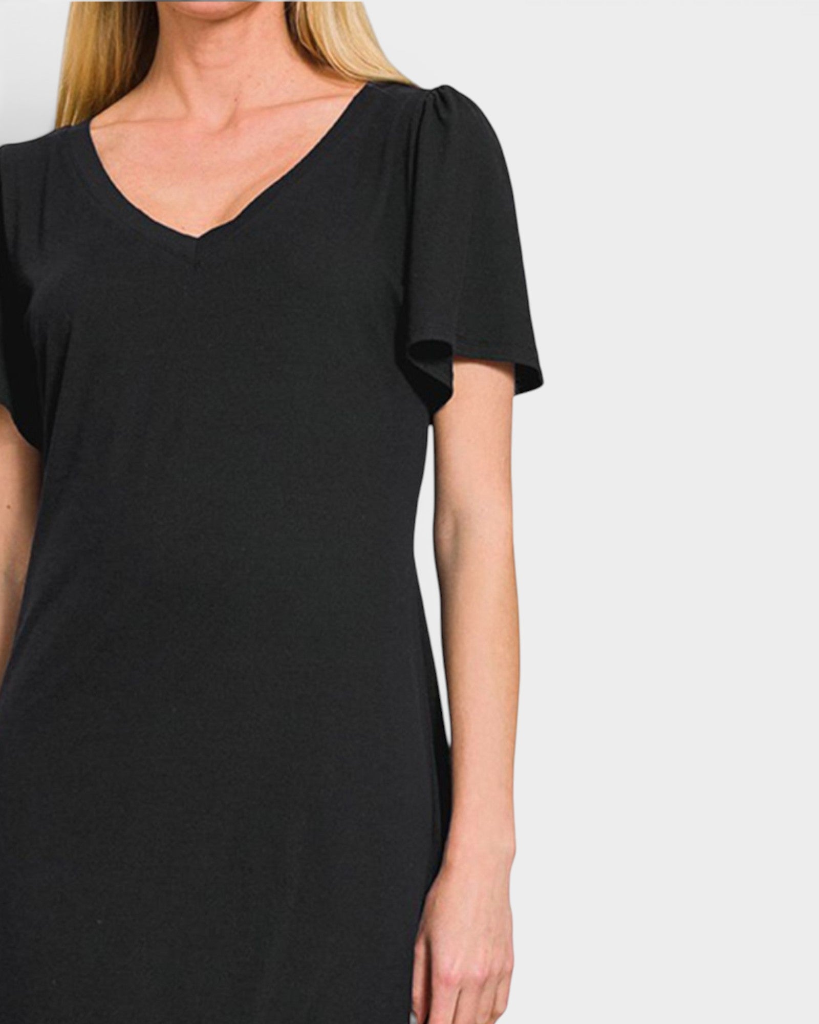 A woman wearing a black short-sleeve V-neck dress with gathered puff sleeves, shown against a light gray studio background.