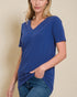 Woman wearing a blue t-shirt against a beige background