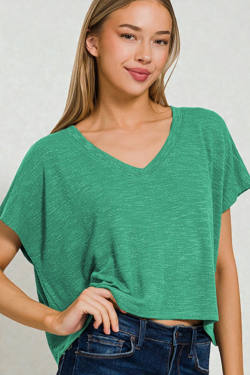 Woman wearing a green oversized t-shirt against a plain background