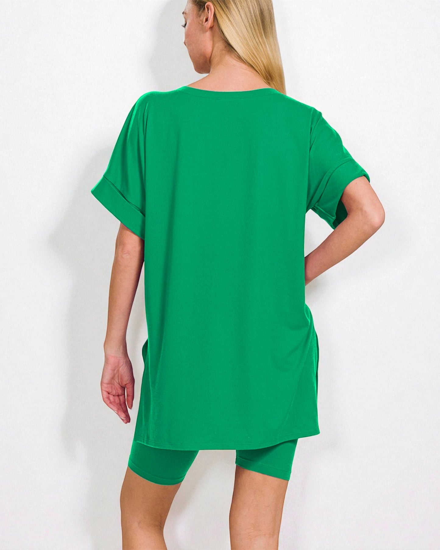 Woman wearing a green oversized t-shirt and shorts set on a white background