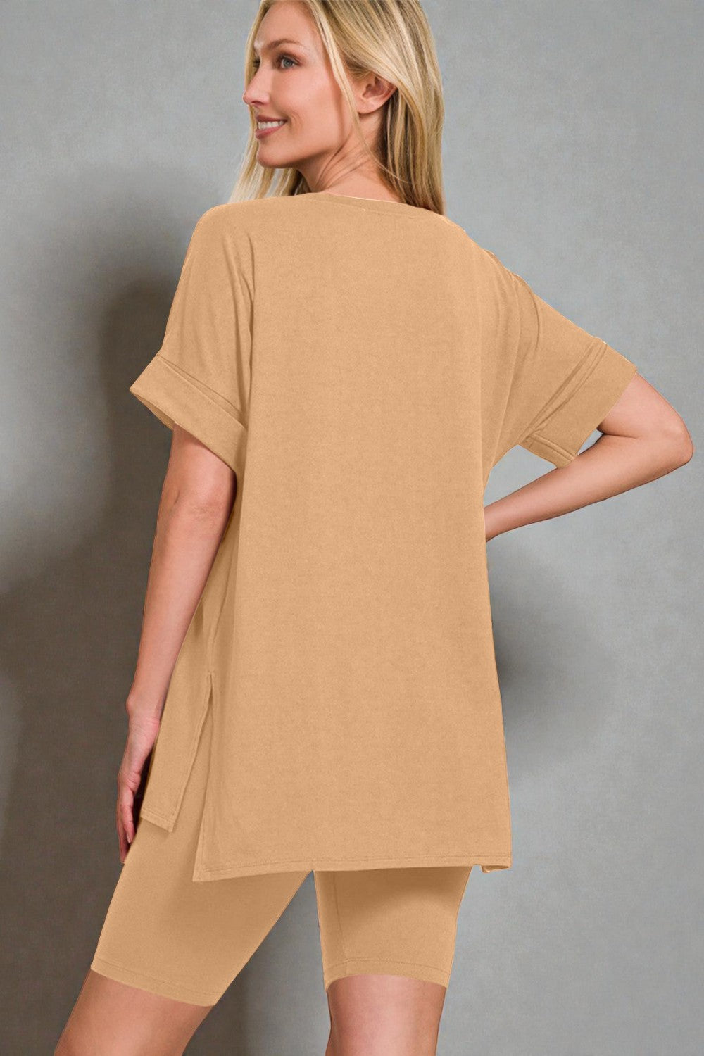 Woman wearing a beige dress against a gray background