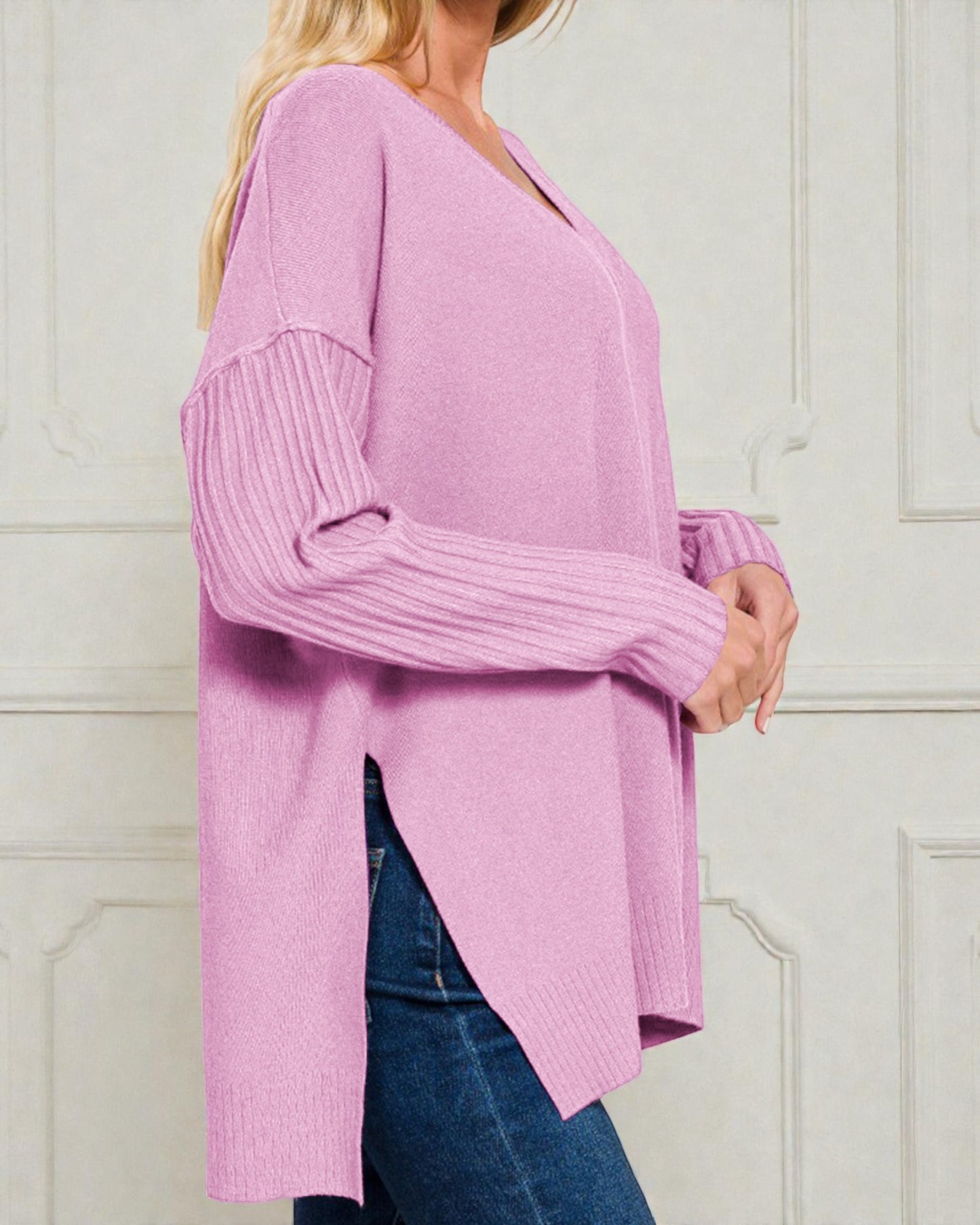 Person wearing a pink sweater with a white background