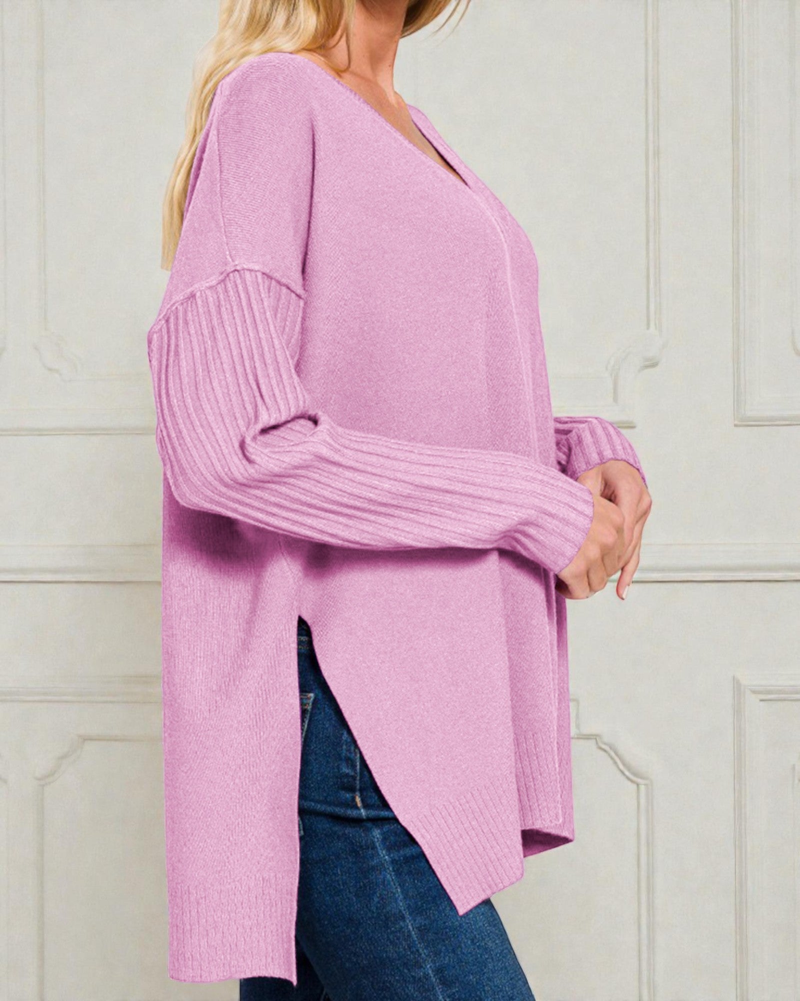 Person wearing a pink sweater with a white background