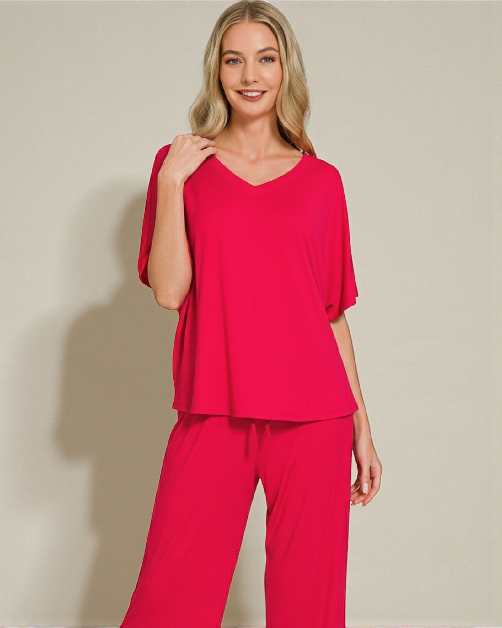 Woman wearing a red outfit against a beige background