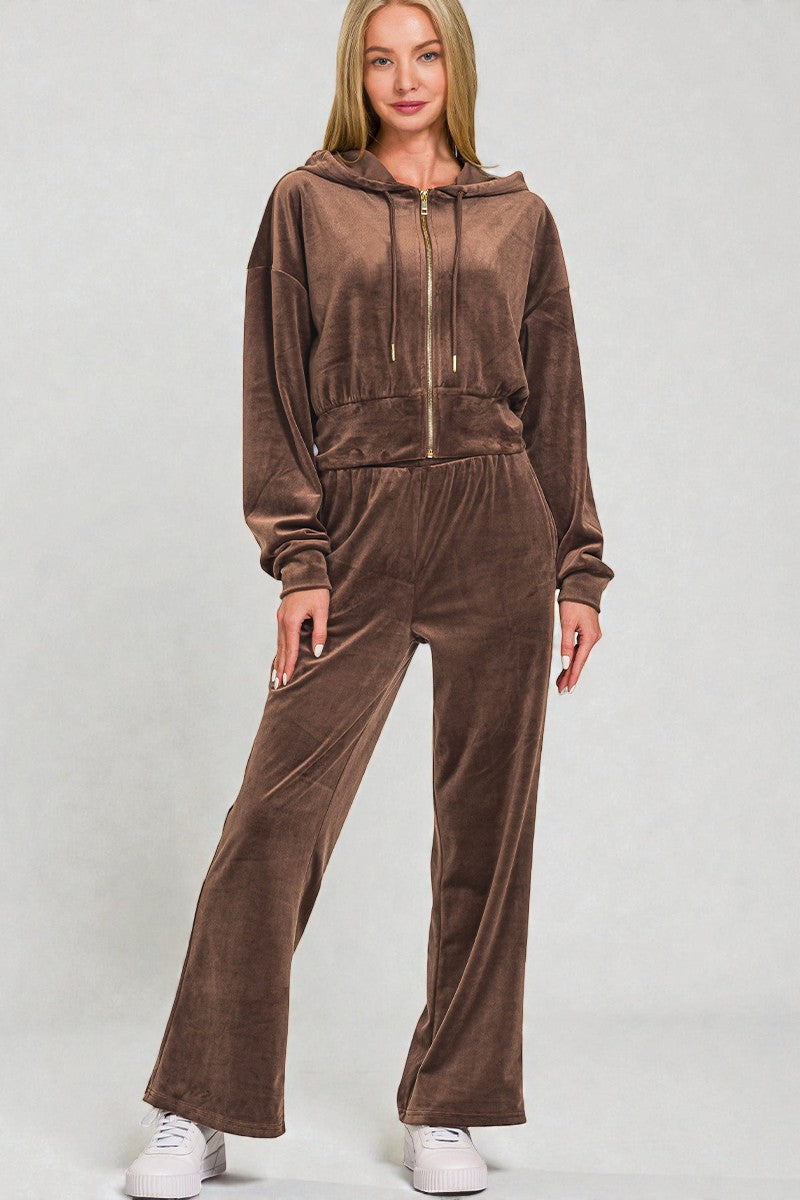 Woman wearing a brown velour tracksuit on a white background