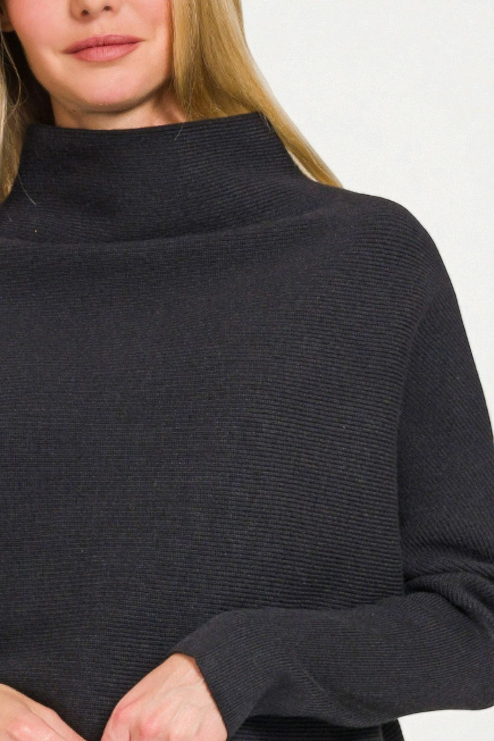 Person wearing a black turtleneck sweater on a white background