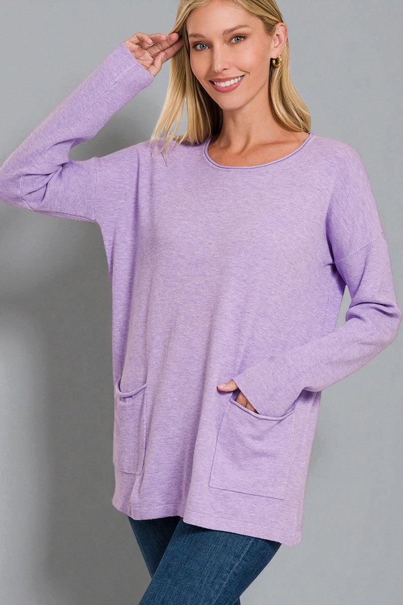 Woman wearing a purple sweater with pockets on a gray background
