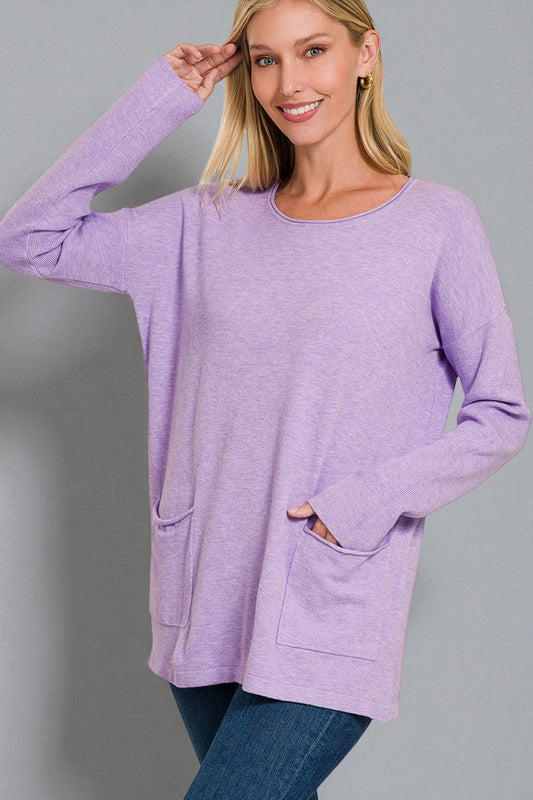 Woman wearing a purple sweater with pockets on a gray background