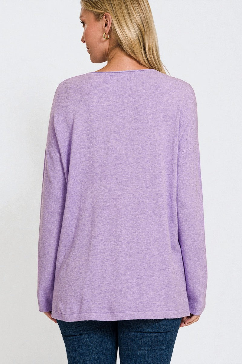 Person wearing a purple long-sleeve top on a white background