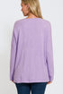 Person wearing a purple long-sleeve top on a white background