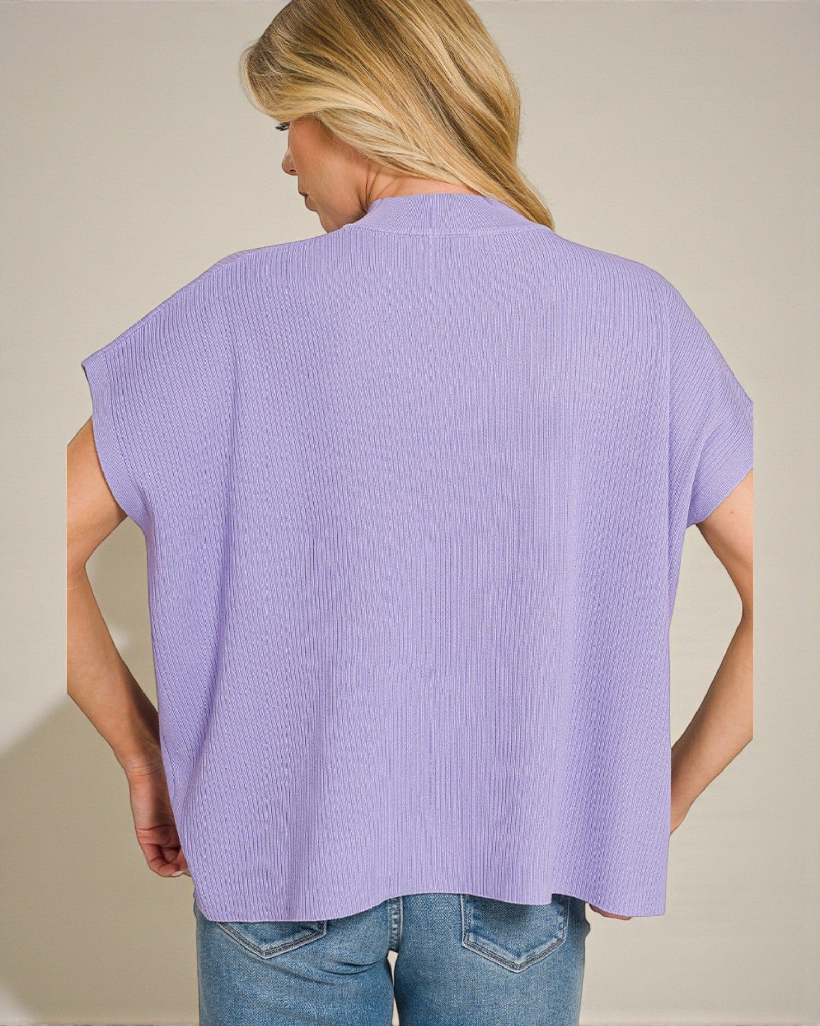 Woman wearing a light purple sleeveless top against a beige background