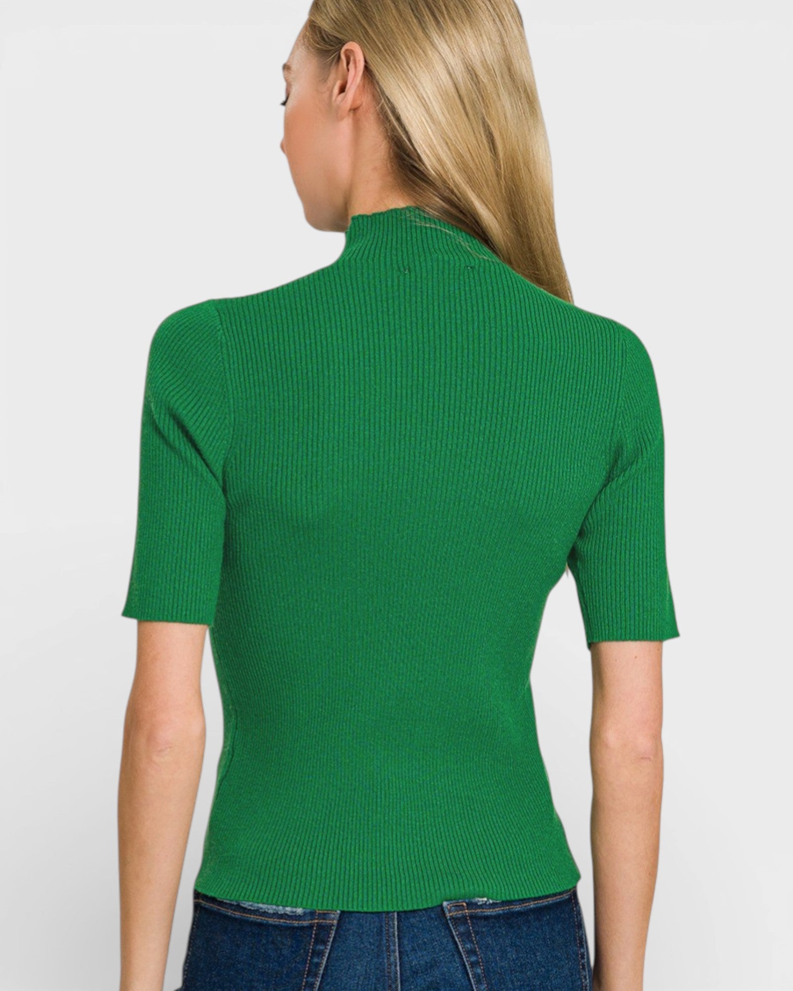 Person wearing a green ribbed top on a plain background