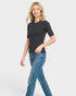 Woman wearing a black t-shirt and blue jeans on a white background
