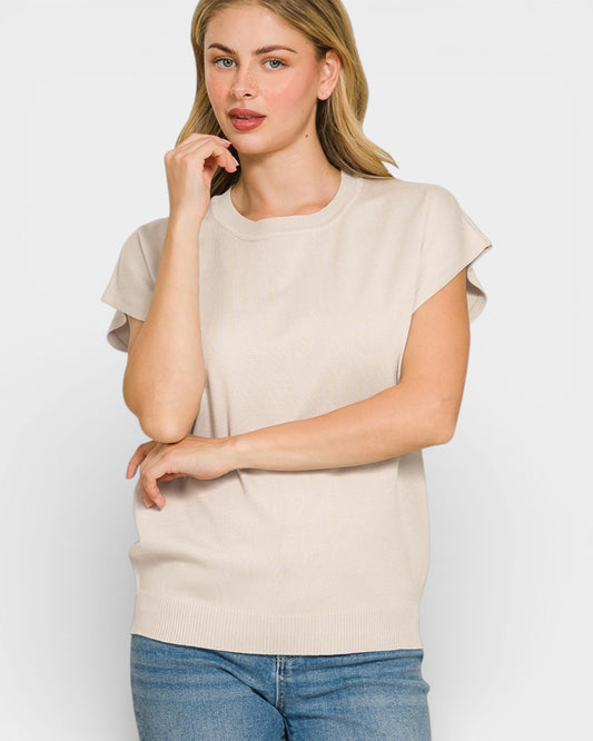 Woman wearing a beige t-shirt and blue jeans on a white background
