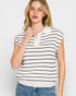 Woman wearing a white and black striped sleeveless top with a plain background