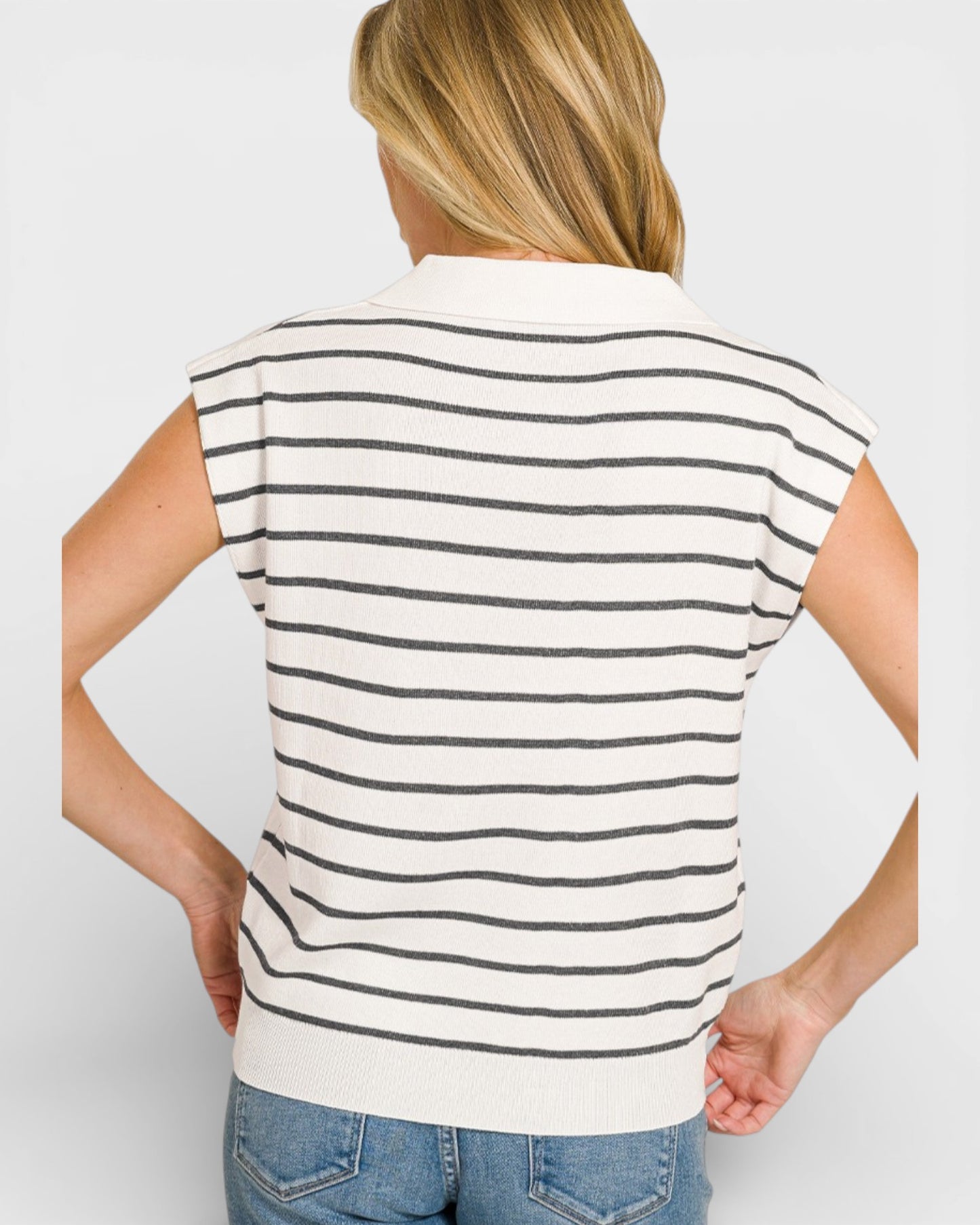 Person wearing a white and black striped shirt on a plain background