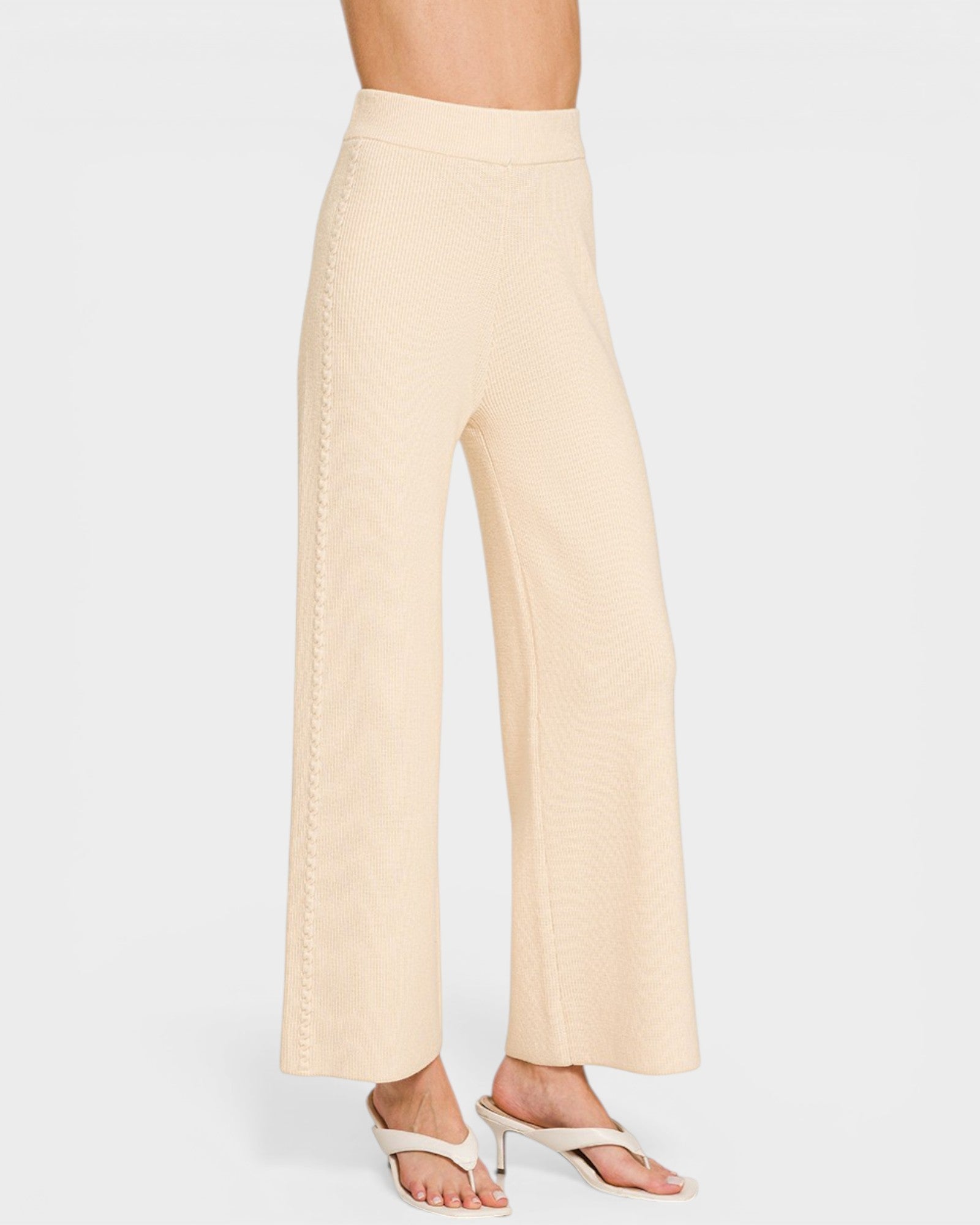 Beige wide-leg pants worn by a person on a white background