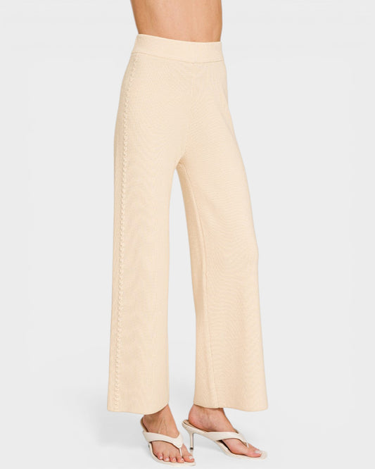 Beige wide-leg pants worn by a person on a white background