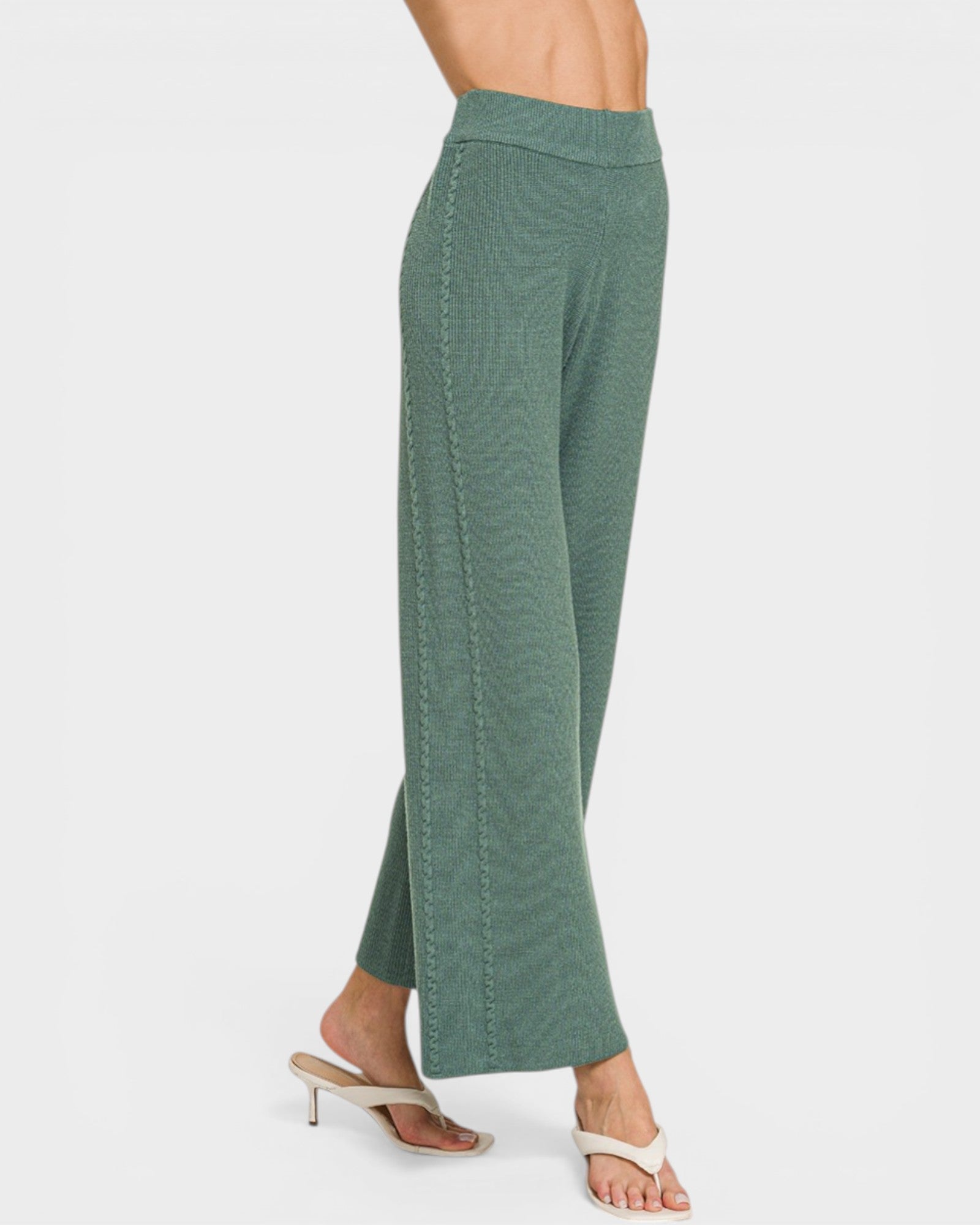 Green pants worn by a person on a white background