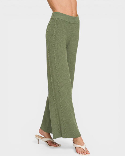 Green flared pants worn by a person on a white background